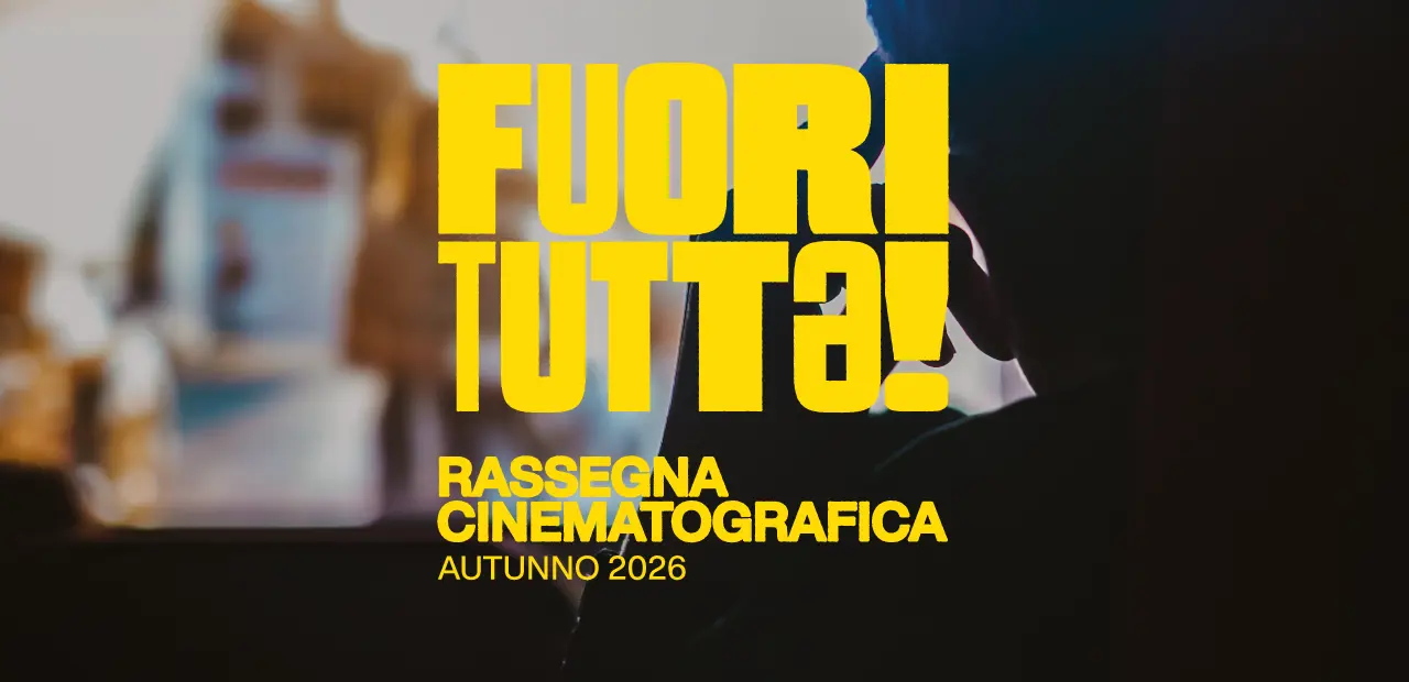 all'interno di una sala cinematografica, vediamo il dettaglio in un profilo visto da dietro. sullo sfondo la proiezione sbiadita