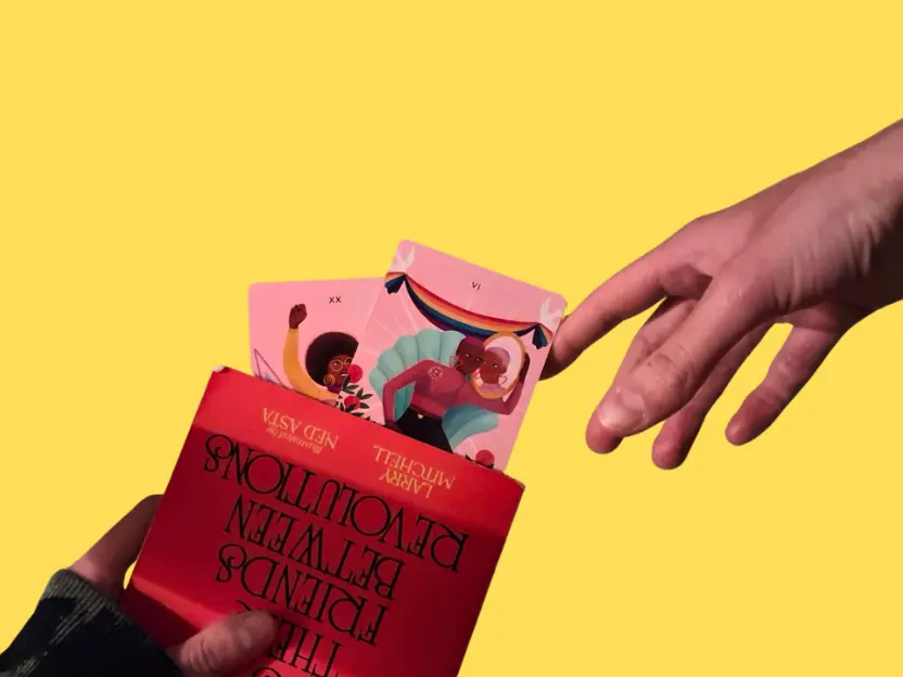 Mano che porge un mazzo di tarocchi colorati da una scatola rossa su sfondo giallo, con illustrazioni inclusive e arcobaleno: un invito giocoso e intimo alla relazione, alla condivisione e alla scoperta reciproca.