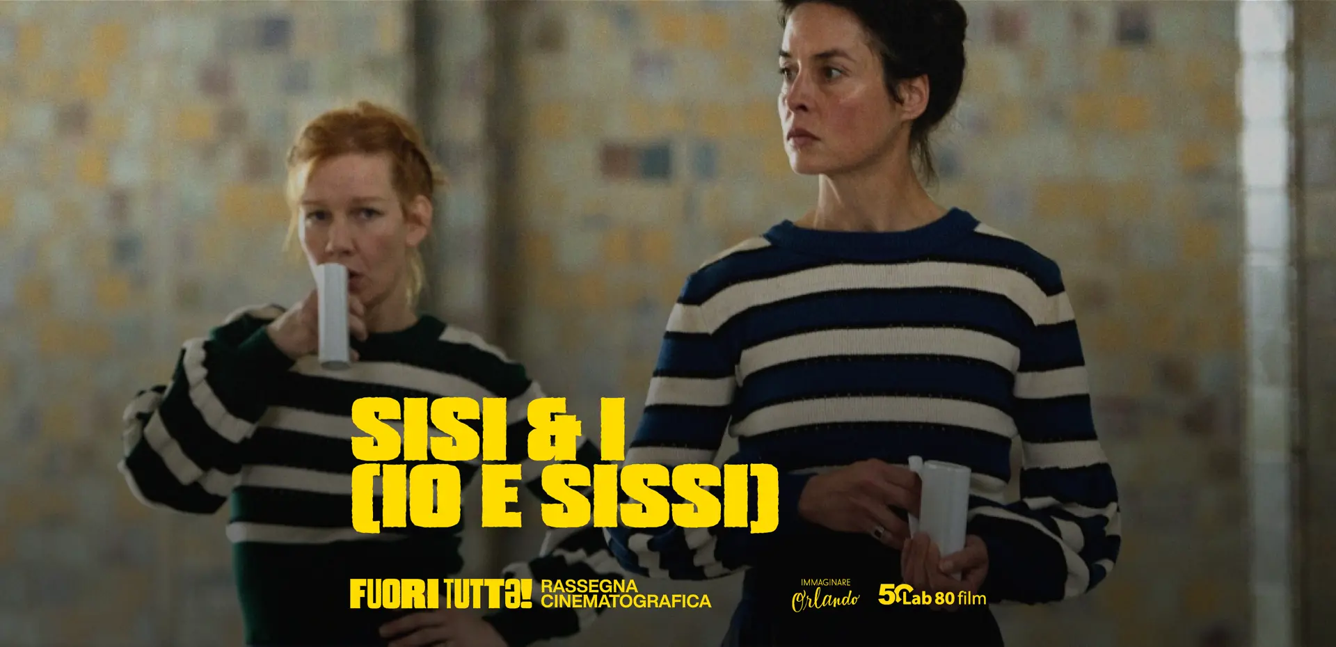 una scena del film con le due protagoniste al centro dell'immagine in piedi che guardano fuori dall'inquadratura